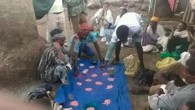 አርሶ አደሮች ማዳበሪያ በጣሳ ሲከፋፈሉ