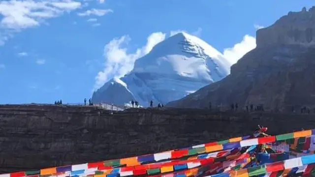 कैलास पर्वतनजिकै उभिएका केही मानिस र टाँगिएको ध्वजापताका