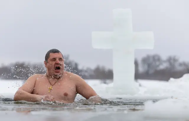 мушкарац израња из ледене воде у граду Ступино у Московској области на богојављање