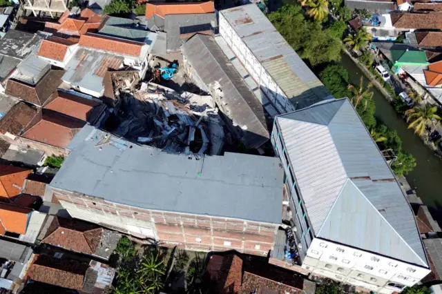 Pekerja menggunakan alat berat saat membongkar puing bangunan mushalla yang ambruk di Pondok Pesantren (Ponpes) Al Khoziny di Kecamatan Buduran, Sidoarjo, Jawa Timur, Kamis (2/10/2025). Pembongkaran bangunan tersebut untuk memudahkan akses tim evakuasi ke korban yang diduga masih banyak yang belum terselamatkan. 