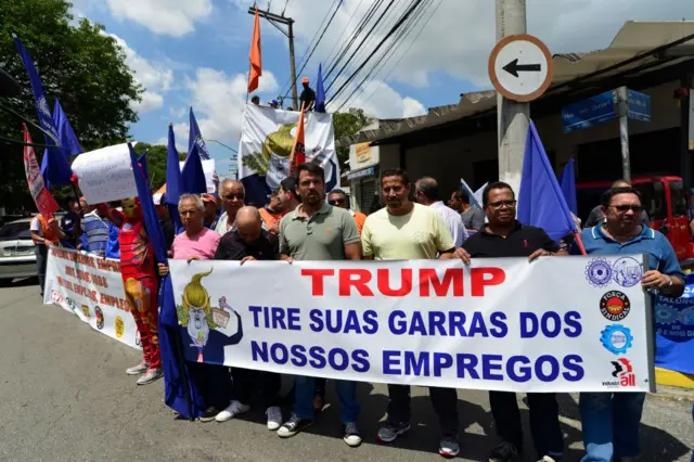 Trabalhadores seguram faixa em manifestação contra protecionismo de Trump no Brasil em 2018