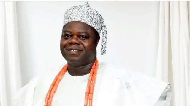 Oba Olajide Okunato pẹlu ade lori ati ilẹkẹ oye lọrun rẹ