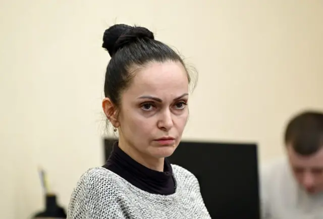 Анна Дудіна із зібраним зверху волоссям у сірій кофті на суті