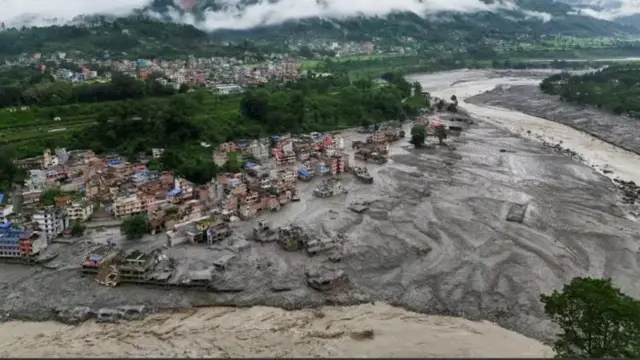 Аерофотознімок наслідків масштабної повені: потік бруду та води вкрив значну частину долини й пошкодив житлову забудову