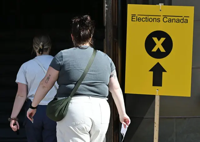Dos mujeres llegan a un centro de votación durante la jornada electoral en Ottawa, Ontario, Canadá, el 28 de abril de 2025.