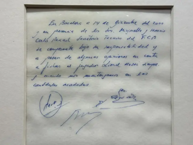 Una servilleta con un mensaje que se lee “En Barcelona, a 14 de diciembre de 2000 y en presencia de los señores Minguella y Horacio, Carles Rexach, director deportivo del FC Barcelona, se compromete, bajo su responsabilidad y con independencia de cualquier opinión contraria, a fichar al jugador Lionel Messi, siempre que se respeten las cantidades acordadas”.