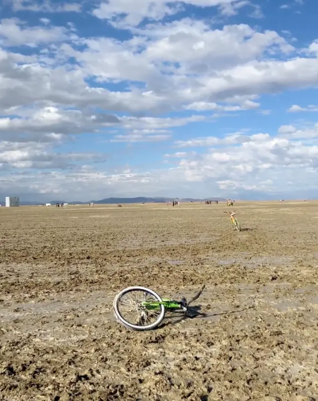 Una bicicleta tirada en el terreno embarrado durante el evento Burning Man.