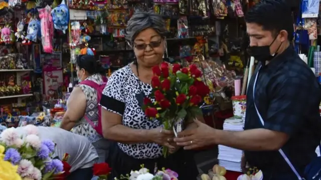 Una mujer vendiendo un ramo de rosas. 