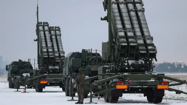 Serviceman patrols in front of the Patriot air defence system during Polish military training on the missile systems at the airport in Warsaw, Poland February 7, 2023