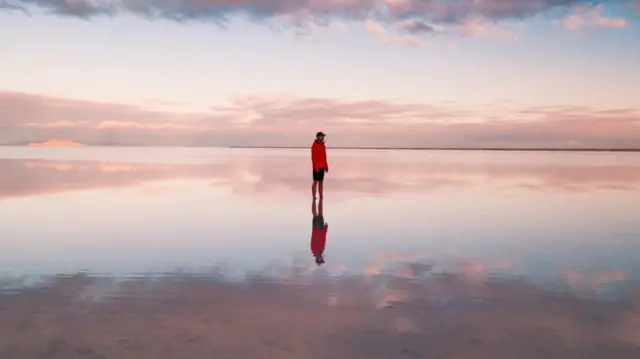 Imagemaposta ganha melhor horário para jogaruma pessoa caminhando solitária na praia