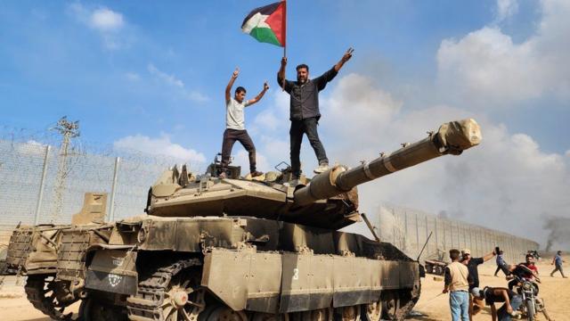 Hombres palestinos sobre un tanque israelí tomado el 7 de octubre