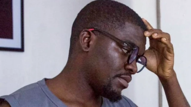 Opeyemi Ademola, wey wear glasses, dem picture, am from side wit one hand for im head