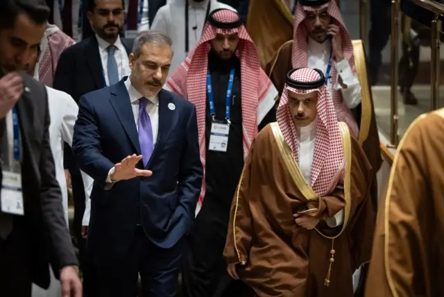 Türkiye Dışişleri Bakanı Hakan Fidan (solda) ve Suudi Arabistan Dışişleri Bakanı Faysal bin Farhan (sağda), 7 Aralık 2024'te Katar'ın Doha kentinde düzenlenen Doha Forumu'nun oturum aralarında konuşuyorlar.