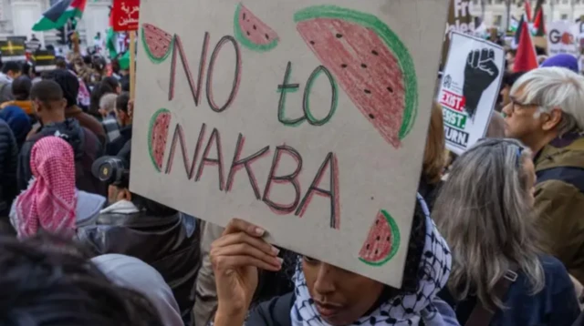 Seorang demonstran pro-Palestina memegang tanda bertuliskan 'Tidak untuk Nakba' dalam unjuk rasa mendukung penduduk Palestina di Gaza pada 14 Oktober 2023 di London, Inggris.