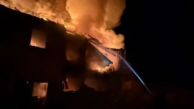 آتش‌نشان‌ها در تلاش برای خاموش کردن آتش یک ساختمان در اوکراین پس از حمله روسیه هستند