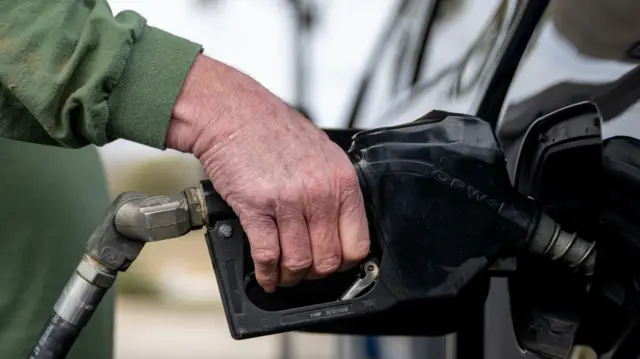 زبون يملأ خزان سيارته بالوقود في محطة وقود شيفرون في أوستن، تكساس، بتاريخ 13 فبراير/شباط 2025.