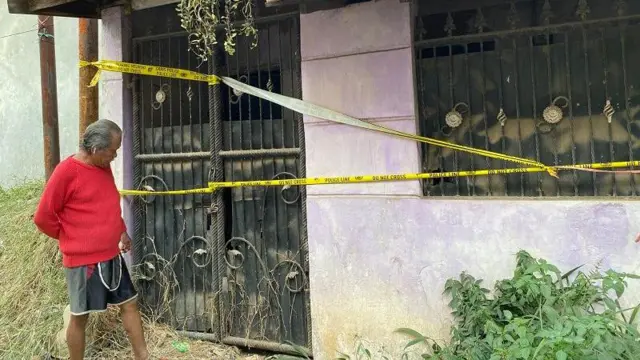 Seorang warga melihat rumah tempat ditemukannya dua kerangka di Perumahan Tanimulya Indah, Kecamatan Ngamprah Kabupaten Bandung Barat.