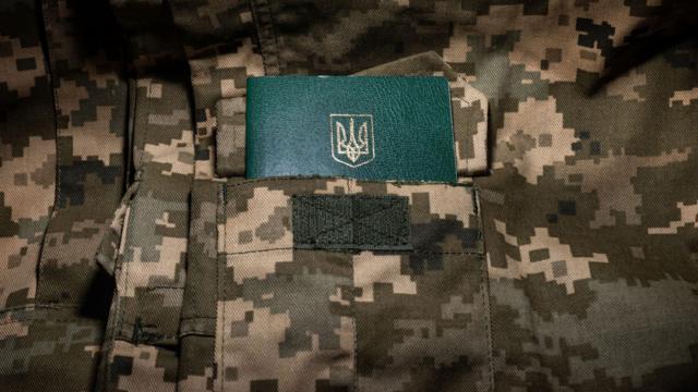 Ukrainian military ID on the background of pixel camouflage uniforms