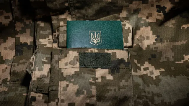 Ukrainian military ID on the background of pixel camouflage uniforms