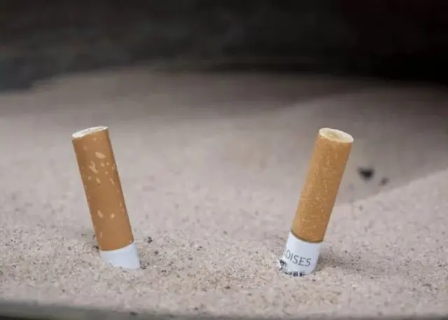 Deux cigarettes enfoncées dans le sable