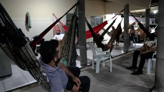Pessoas deitadas em redes