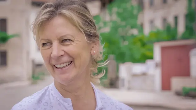 تصویری نزدیک از زنی که لبخند می‌زند و به گوشه‌ای نگاه می‌کند