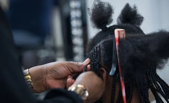 Close-up of Kellie-Ann's hair being braided