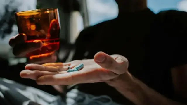 ART ဆေးလုံးတွေကို လက်ဖဝါးထဲထည့်ထားပြီး လက်တဖက်မှာ ရေခွက်ကိုင်ထားတဲ့ မြင်ကွင်း 