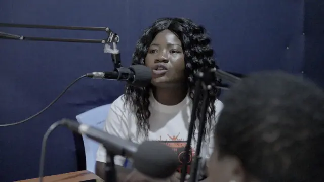 Jeune fille face à un micro dans un studio radio
