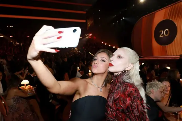 Lady Gaga (iburyo) hamwe n'umuhanzi mugenzi we Tate McRae bafta selfie 