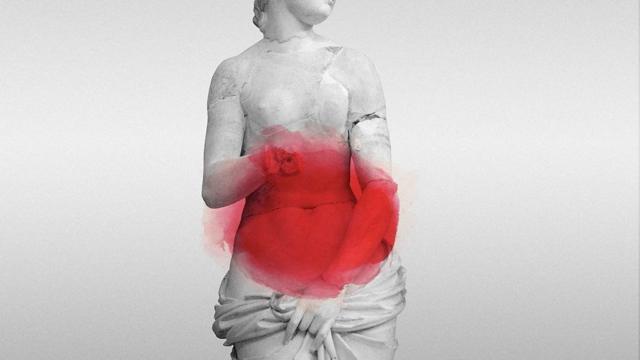 Estátua de mulher com mancha vermelha no abdômen sugerindo dores na região