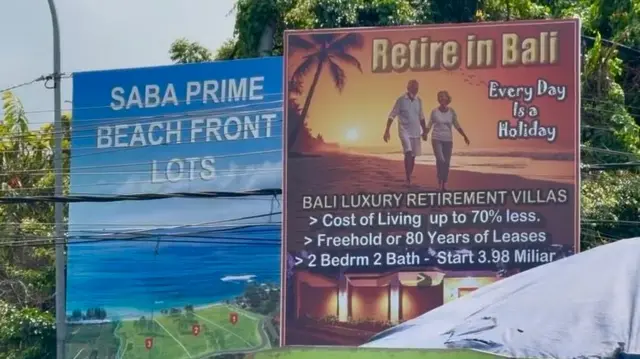 Dua billboard di pinggir jalan menawarkan investasi vila di Bali.