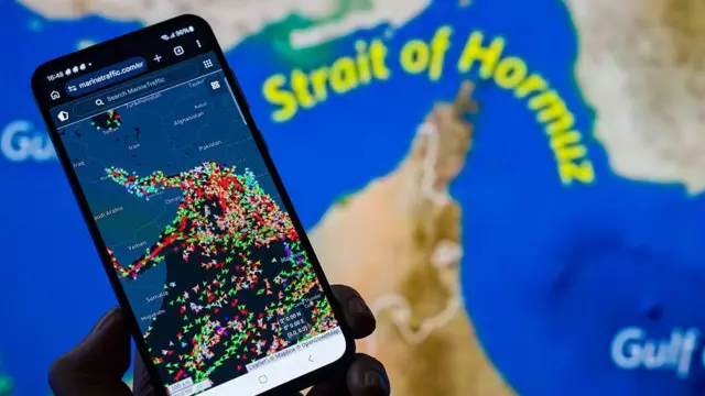 Peta MarineTraffic yang menunjukkan pergerakan kapal di Selat Hormuz ditampilkan di layar ponsel pada 15 Maret 2026. Nampak menurunnya lalu lintas kapal komersial yang melalui jalur pelayaran minyak utama di tengah konflik yang sedang berlangsung yang melibatkan Iran. 
