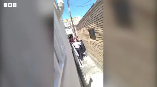گروهی انسان در کوچه باریک که هستی می‌گوید همسایه‌هایشان هستند به خانه آنها در محله‌ای از تبریز حمله کردند