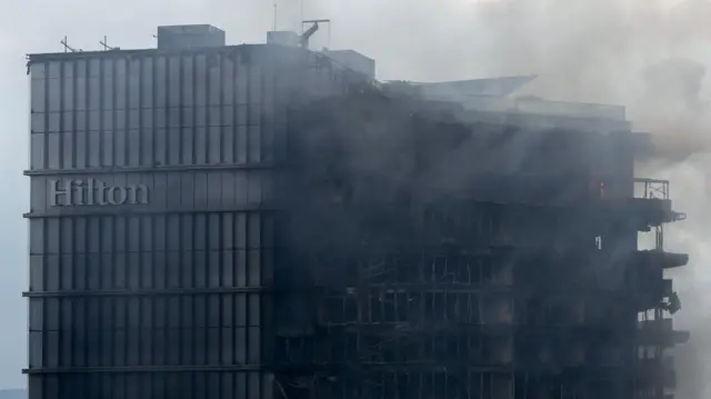 加德满都希尔顿酒店遭纵火后浓烟升起，此前因政府封禁社交平台引发的反贪腐抗议，造成周一19人遇难。