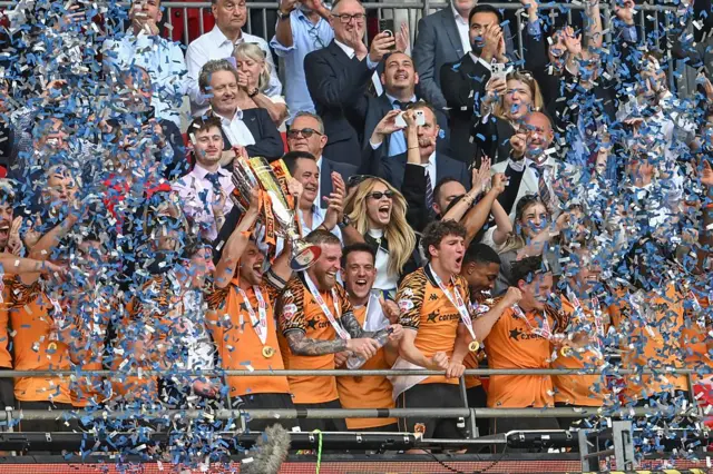 Hull City'li futbolcular ve teknik ekip kupayı kaldırıyorlar. Üzerlerinden konfeti yağıyor
