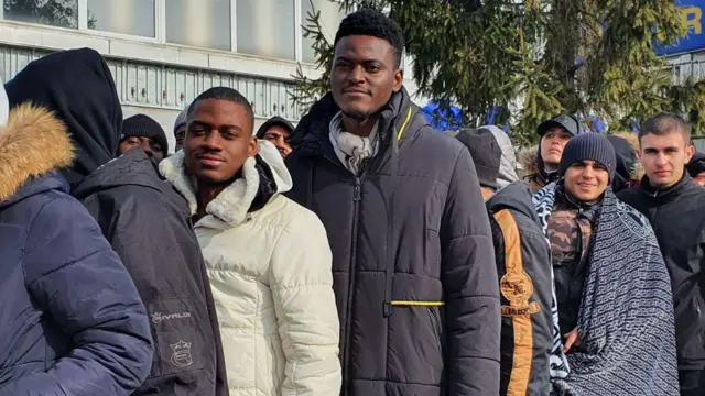 Des étrangers attendent pour se rendre en Pologne au poste frontière ukrainien de Shegyni, le 1er mars 2022.