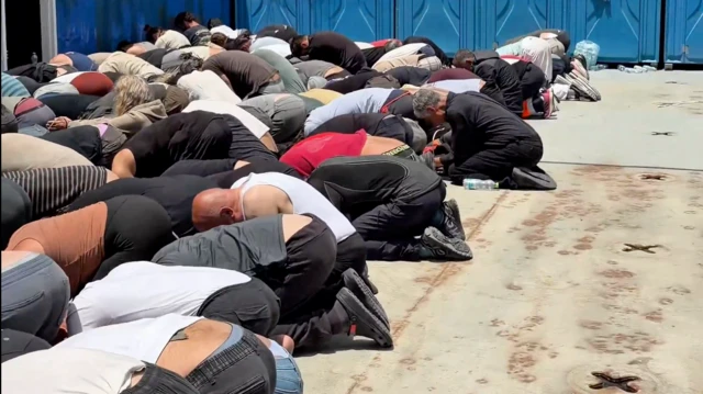 Yere dizlere üzerinde çöktürülmüş insanlar var. Gözaltında oldukları anlaşılıyor.
