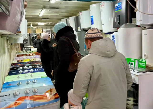 Bozordagi odamlar va mahsulotlar.