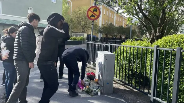 Молоді люди залишають квіти на розі вулиці біля перукарні