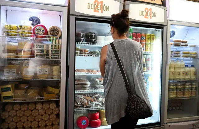 Una mujer elige productos en un pequeño bodegón de aparente exclusividad en La Habana. 