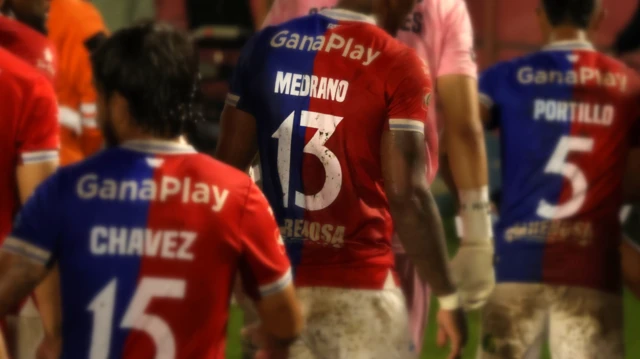 Diversos jogadores do FAS de costas, com o atacante Edgar Medrano no centro, com a camisa 13 com seu sobrenome, no Estádio Óscar Alberto Quiteño em 11 de outubro de 2025, quando o time local do FAS enfrentou o Municipal Limeño, em Santa Ana, El Salvador