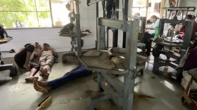 सूरत की एक फ़ैक्ट्री में आराम करते कारीगर