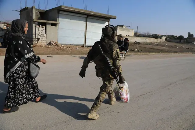 Suriye ordusu SDG'nin bölgeden çıkmasının Halep'e bağlı Sarrin kasabasında yerel halka gıda yardımı paketleri dağıtırken. 