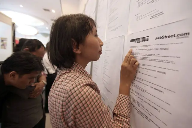 Pencari kerja Nurul Mardiyanti, 22 tahun, melihat lowongan pekerjaan di bursa kerja.