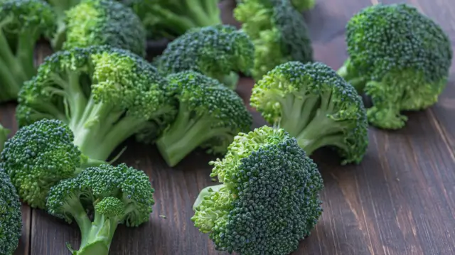 Vários brócolis sobre uma superfície de madeira