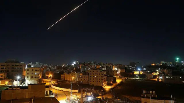 Un misil y su estela, en el cielo nocturno sobre una ciudad israelí.