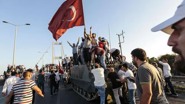 Susținătorii președintelui Recep Tayyip Erdogan flutură steaguri turcești în timp ce capturează un tanc al armatei, după ce soldații implicați în tentativa de lovitură de stat au capitulat pe Podul Bosfor din Istanbul.