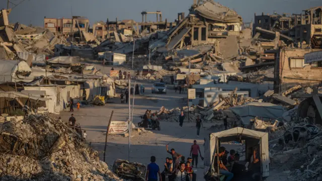 Palestinos desplazados caminan entre casas destruidas en Jabaliya, norte de la ciudad de Gaza, 7 de agosto de 2026