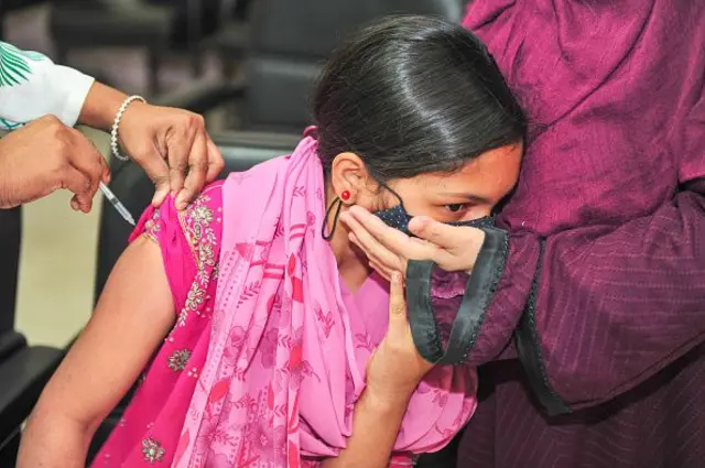 কিশোরীর বাহুতে ইনজেকশন দেয়া হচ্ছে। সে মুখ ফিরিয়ে আছে।